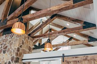 Ceiling of a house with wooden beams and rafters exposed and hanging lights between the rafters. Original public domain image from Wikimedia Commons