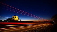 A gleaming red light trail shining down a dark road in Victoria. Original public domain image from Wikimedia Commons