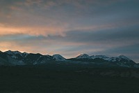Thick clouds gather over snowy mountains as the evening sets in. Original public domain image from <a href="https://commons.wikimedia.org/wiki/File:Cloudy_mountains_(Unsplash).jpg" target="_blank" rel="noopener noreferrer nofollow">Wikimedia Commons</a>