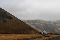 Lone farmhouse in Iceland in a field near foggy hills. Original public domain image from Wikimedia Commons