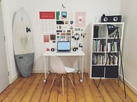 Small home office with a surfing board in the corner next to a desk on wheels. Original public domain image from <a href="https://commons.wikimedia.org/wiki/File:Surf-station_(Unsplash).jpg" target="_blank">Wikimedia Commons</a>