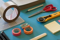 Colorful rolls of scotch tape, scissors and sticky notes on a table. Original public domain image from Wikimedia Commons