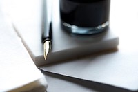 The glossy tip of a fountain pen next to a drinking glass. Original public domain image from Wikimedia Commons