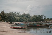 Many longtail boats at the sandy shore in Phuket. Original public domain image from Wikimedia Commons