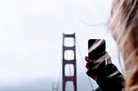 Woman taking a photo of a Golden Gate Bridge in San Francisco, United States. Original public domain image from Wikimedia Commons