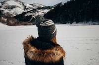 A woman in a fur coat and hat staring at a snow-covered mountain. Original public domain image from Wikimedia Commons