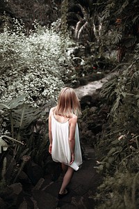 Woman walking through a forest. Original public domain image from Wikimedia Commons