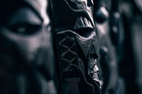 A dim close-up of wooden tribal masks. Original public domain image from Wikimedia Commons