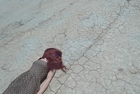 Woman with hair over face lying down on cracked desert floor. Original public domain image from <a href="https://commons.wikimedia.org/wiki/File:Exhausted_From_The_Heat_(Unsplash).jpg" target="_blank" rel="noopener noreferrer nofollow">Wikimedia Commons</a>