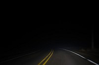 A dark night photograph from dash view of a car driving on a two-way road in Fenton. Original public domain image from Wikimedia Commons