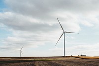 Wind turbines create green energy in a farm field. Original public domain image from <a href="https://commons.wikimedia.org/wiki/File:Farm_Windmills_(Unsplash).jpg" target="_blank" rel="noopener noreferrer nofollow">Wikimedia Commons</a>
