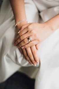 Woman wearing a gold diamond rings in a white dress. Original public domain image from Wikimedia Commons