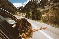Young woman leans out car window to feel the fresh mountain air. Original public domain image from <a href="https://commons.wikimedia.org/wiki/File:The_way_to_the_cabin_(Unsplash_5d20kdvFCfA).jpg" target="_blank" rel="noopener noreferrer nofollow">Wikimedia Commons</a>