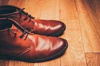 A pair of brown leather boots with the shoestrings tucked in on wooden flooring. Original public domain image from <a href="https://commons.wikimedia.org/wiki/File:Brown_leather_boots_on_a_wood_floor_(Unsplash).jpg" target="_blank" rel="noopener noreferrer nofollow">Wikimedia Commons</a>
