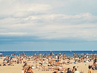 Beach is crowded with people on tourism enjoying the summer holiday and vacation in Barcelona. Original public domain image from Wikimedia Commons