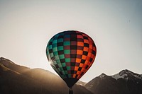 A red and blue hot air balloon soaring above the mountains in Telluride. Original public domain image from Wikimedia Commons