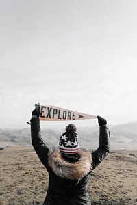 Person holding flag with explore word. Original public domain image from Wikimedia Commons