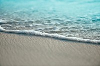 Ocean foam washing on a sand beach in Kudafari. Original public domain image from Wikimedia Commons