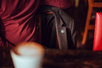 A blazer with an Unsplash pin, hanging on a chair at a cafe table. Original public domain image from <a href="https://commons.wikimedia.org/wiki/File:Unsplash_lapel_pin_(Unsplash).jpg" target="_blank" rel="noopener noreferrer nofollow">Wikimedia Commons</a>