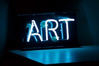 White neon art sign with table reflection in Shitennōji-mae Yūhigaoka Station. Original public domain image from Wikimedia Commons