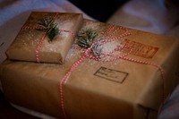 Christmas gift parcels wrapped in brown paper and decorated with twine and pine leaves.. Original public domain image from Wikimedia Commons