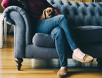 Women sitting on a couch with her dog on the lap. Original public domain image from Wikimedia Commons