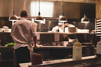 A chef preparing food in the kitchen of a restaurant. Original public domain image from <a href="https://commons.wikimedia.org/wiki/File:Chefs_at_Work_(Unsplash).jpg" target="_blank" rel="noopener noreferrer nofollow">Wikimedia Commons</a>