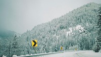 Yellow and black chevron signs on the side of a snowy road in the Rocky Mountains. Original public domain image from Wikimedia Commons