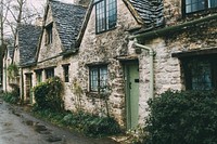 A cottage building with a tile roof and plants in front of it in an old street. Original public domain image from Wikimedia Commons