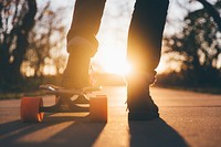 The silhouette of a person riding a skateboard with orange wheels at sunset at University of Northern Iowa. Original public domain image from Wikimedia Commons