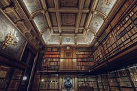 A large library or study filled with lots of books, ornate ceilings, and two levels in Chantilly. Original public domain image from <a href="https://commons.wikimedia.org/wiki/File:Chantilly_library_study_(Unsplash).jpg" target="_blank" rel="noopener noreferrer nofollow">Wikimedia Commons</a>