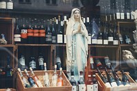 A statue of Virgin Mary with a rosary in a wine store. Original public domain image from <a href="https://commons.wikimedia.org/wiki/File:Rosary_and_wine_(Unsplash).jpg" target="_blank" rel="noopener noreferrer nofollow">Wikimedia Commons</a>