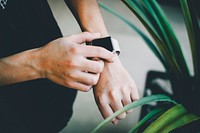 Person about to use silver Apple Watch  in grey sports band. Original public domain image from Wikimedia Commons