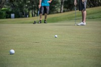 Two men putting to see who can score first on a golf hole. Original public domain image from Wikimedia Commons