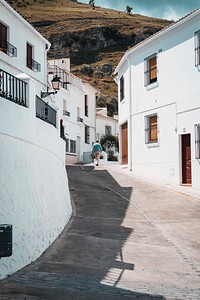 A man walking near houses in a village. Original public domain image from Wikimedia Commons