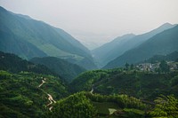 A village on a green hill overlooking a valley. Original public domain image from Wikimedia Commons