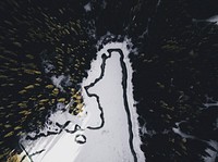 A drone shot of the unfrozen zigzagging shore of lake Caumasee. Original public domain image from Wikimedia Commons