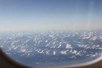 View from an airplane window on a vast mountainous area. Original public domain image from Wikimedia Commons