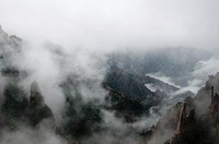 Fog rolling down the rugged mountain ridges of the Huangshan mountain range. Original public domain image from Wikimedia Commons