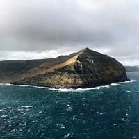 A cliff over choppy azure sea water in the Faroe Islands. Original public domain image from Wikimedia Commons