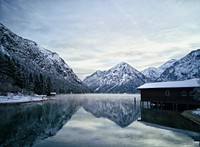 A cabin on a misty mountain lake in Heiterwang in the winter. Original public domain image from Wikimedia Commons