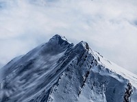 An imposing snow-capped summit against an overcast sky. Original public domain image from <a href="https://commons.wikimedia.org/wiki/File:Snow-covered_summit_(Unsplash).jpg" target="_blank" rel="noopener noreferrer nofollow">Wikimedia Commons</a>