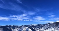 A low snow-capped mountain range under a blue sky. Original public domain image from <a href="https://commons.wikimedia.org/wiki/File:Blue_skies_and_patchy_clouds_(Unsplash).jpg" target="_blank" rel="noopener noreferrer nofollow">Wikimedia Commons</a>