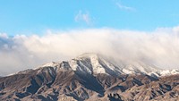 A scenic view of a snow covered mountain top with fog and a clear blue sky in Indio.. Original public domain image from <a href="https://commons.wikimedia.org/wiki/File:Snow_covered_mountains_in_Indio_(Unsplash).jpg" target="_blank" rel="noopener noreferrer nofollow">Wikimedia Commons</a>