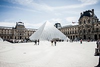Groups of people walking in front of the glass pyramid in the Louvre courtyard in Paris. Original public domain image from <a href="https://commons.wikimedia.org/wiki/File:Louvre_courtyard_with_visitors_(Unsplash).jpg" target="_blank" rel="noopener noreferrer nofollow">Wikimedia Commons</a>