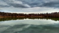 A smooth lake under heavy gray clouds in the autumn. Original public domain image from Wikimedia Commons