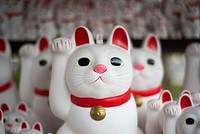 A number of Japanese maneki-neko figurines depicting a beckoning white cat. Original public domain image from Wikimedia Commons