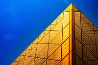 The edge of a golden facade with tiles in geometric shapes. Original public domain image from <a href="https://commons.wikimedia.org/wiki/File:Tokyo_Big_Sight_(Unsplash).jpg" target="_blank" rel="noopener noreferrer nofollow">Wikimedia Commons</a>