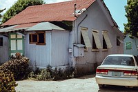 An old house with a car parked in the driveway.. Original public domain image from Wikimedia Commons
