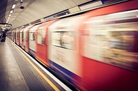 Tube train passing station with motion blur as passengers wait in the United Kingdom. Original public domain image from <a href="https://commons.wikimedia.org/wiki/File:Tube_train_motion_blur_(Unsplash).jpg" target="_blank" rel="noopener noreferrer nofollow">Wikimedia Commons</a>